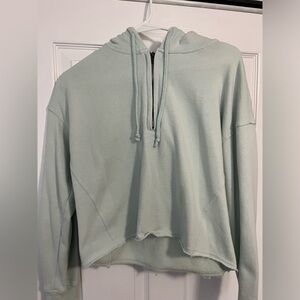 Cropped teal quarter zip hoodie.